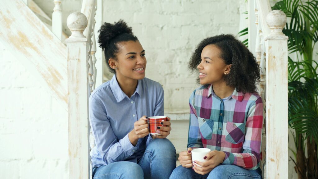 Two young women sharing stories while drinking tea